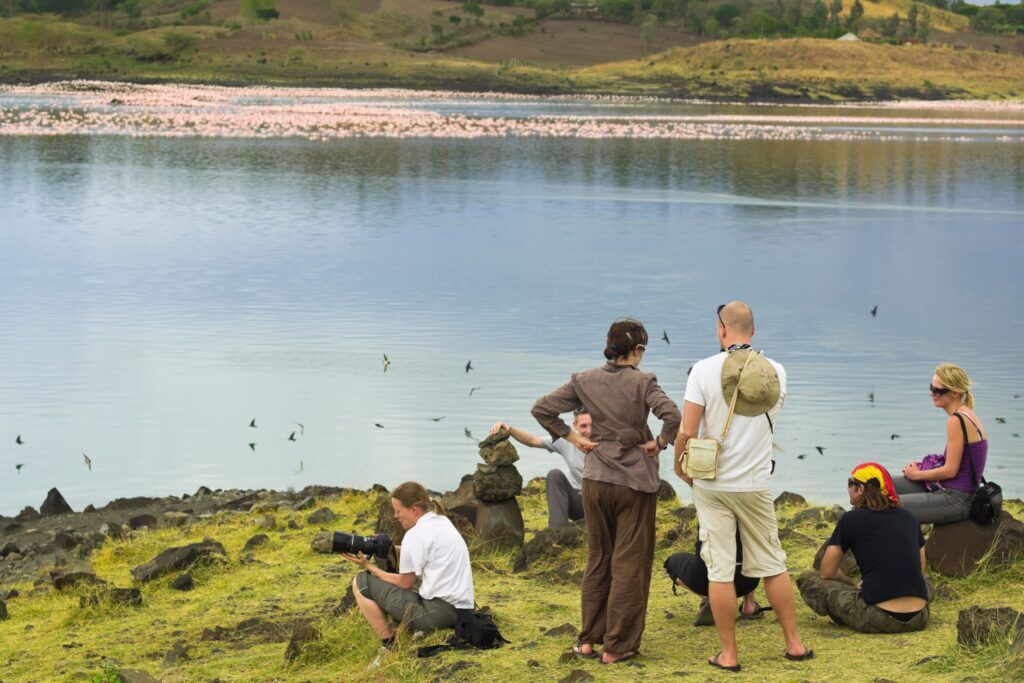 A group of people standing on the shore of Lake Momella, Tanzania