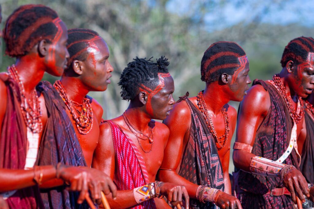 Maasai warriors with red colour on their skin and traditional clothes